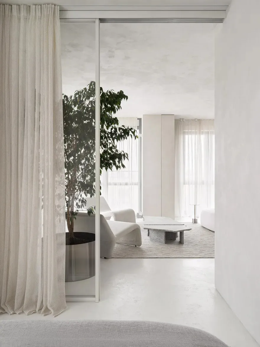 A minimalist living room featuring clean lines and a concrete floor.