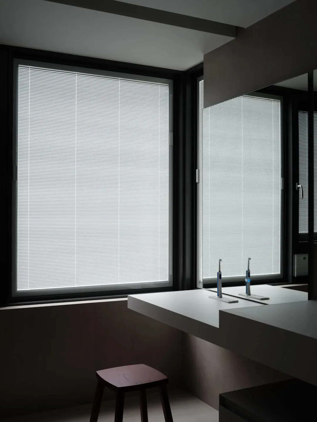 Bathroom interior featuring large windows with aluminum blinds.