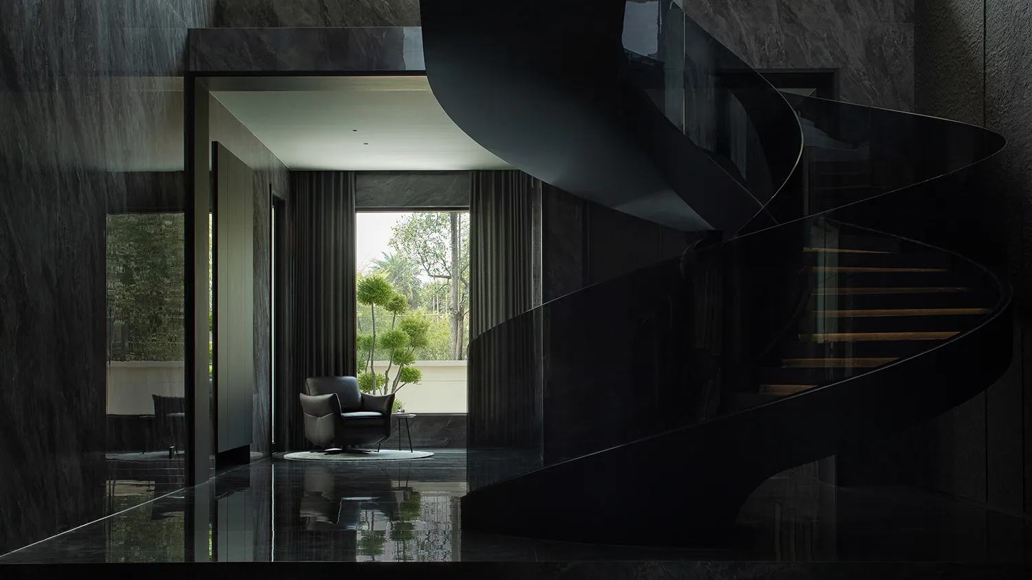 A modern black staircase with glass railings and marble flooring.