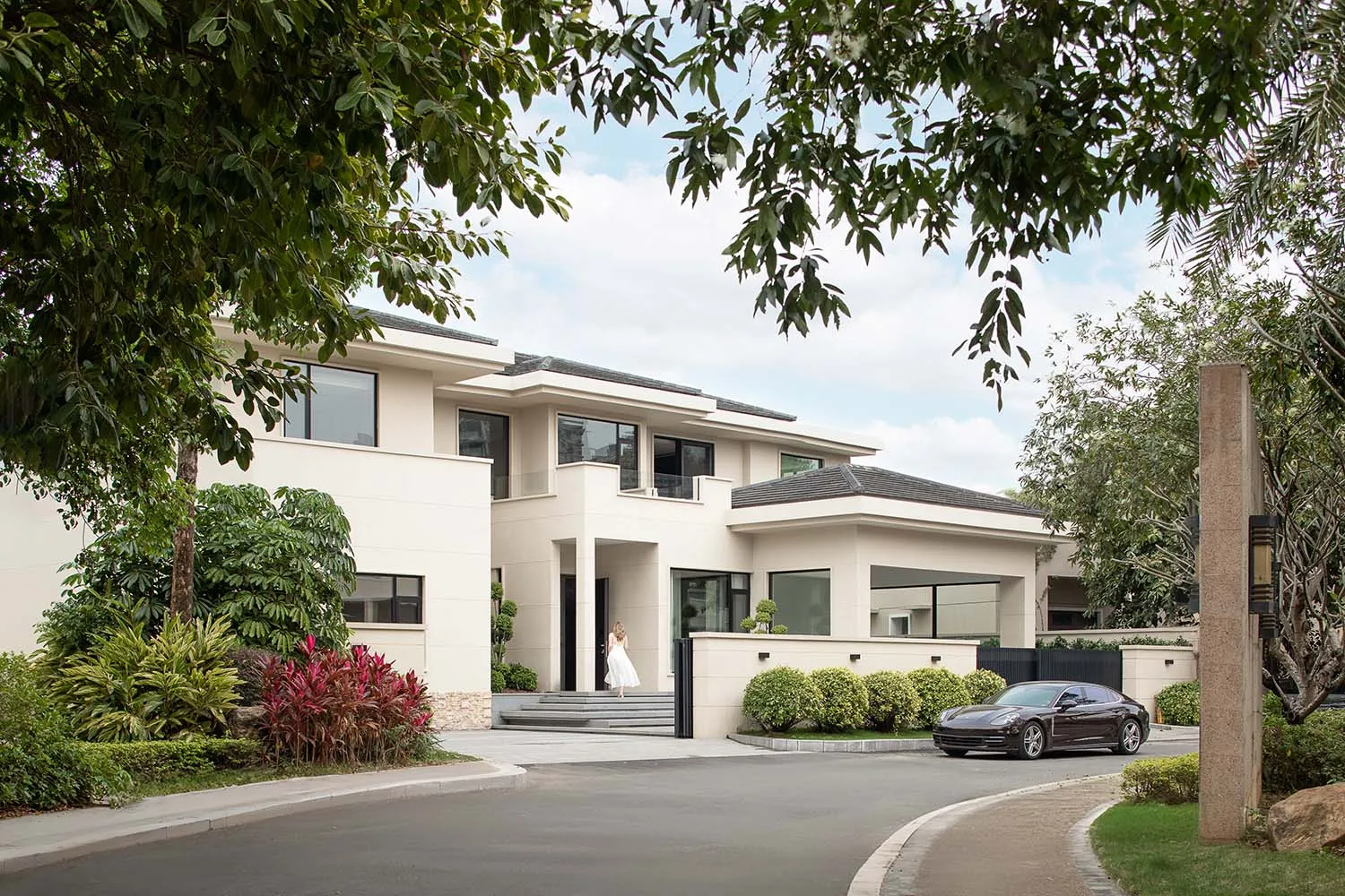 Modern residential exterior featuring contemporary design elements with concrete and glass materials.