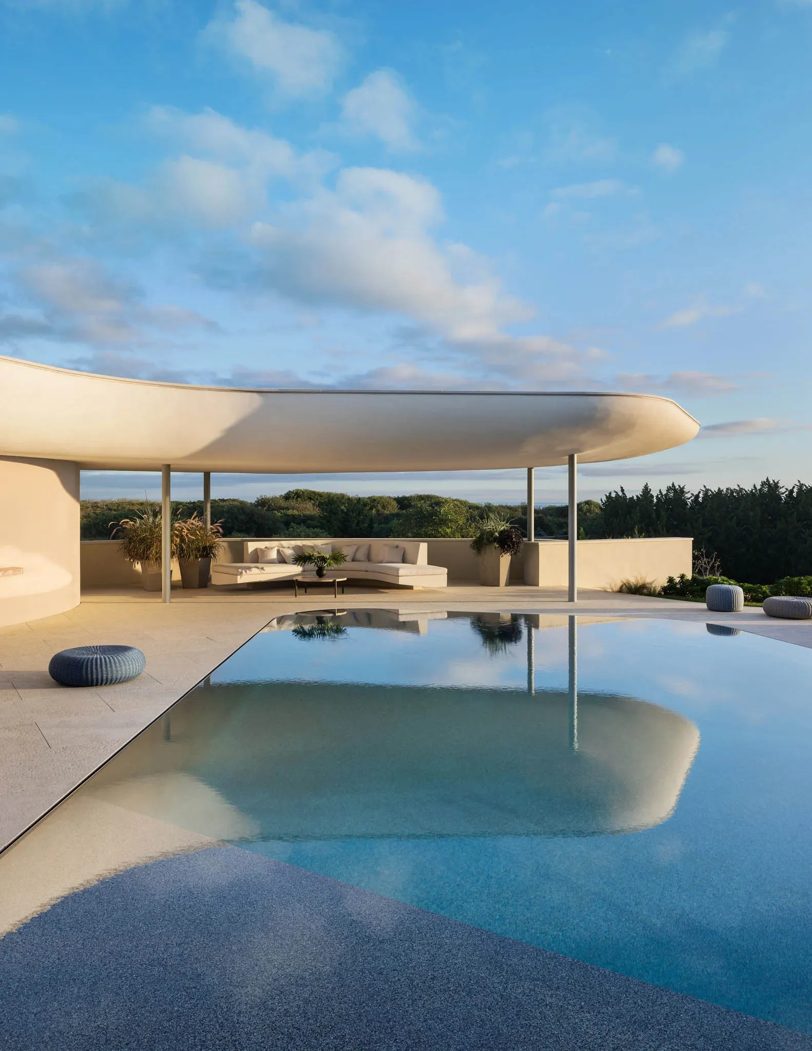 A minimalist pool area featuring concrete and glass materials.