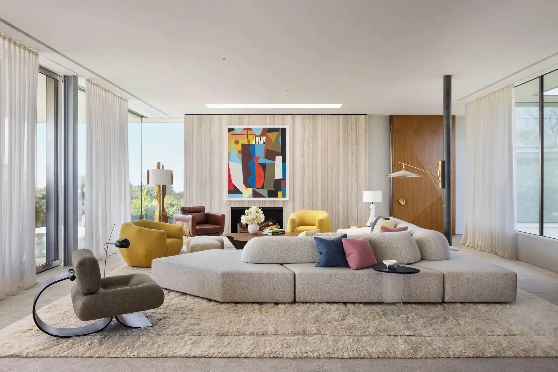 A modern living room featuring a fabric sofa, yellow armchairs, and a geometric abstract painting.