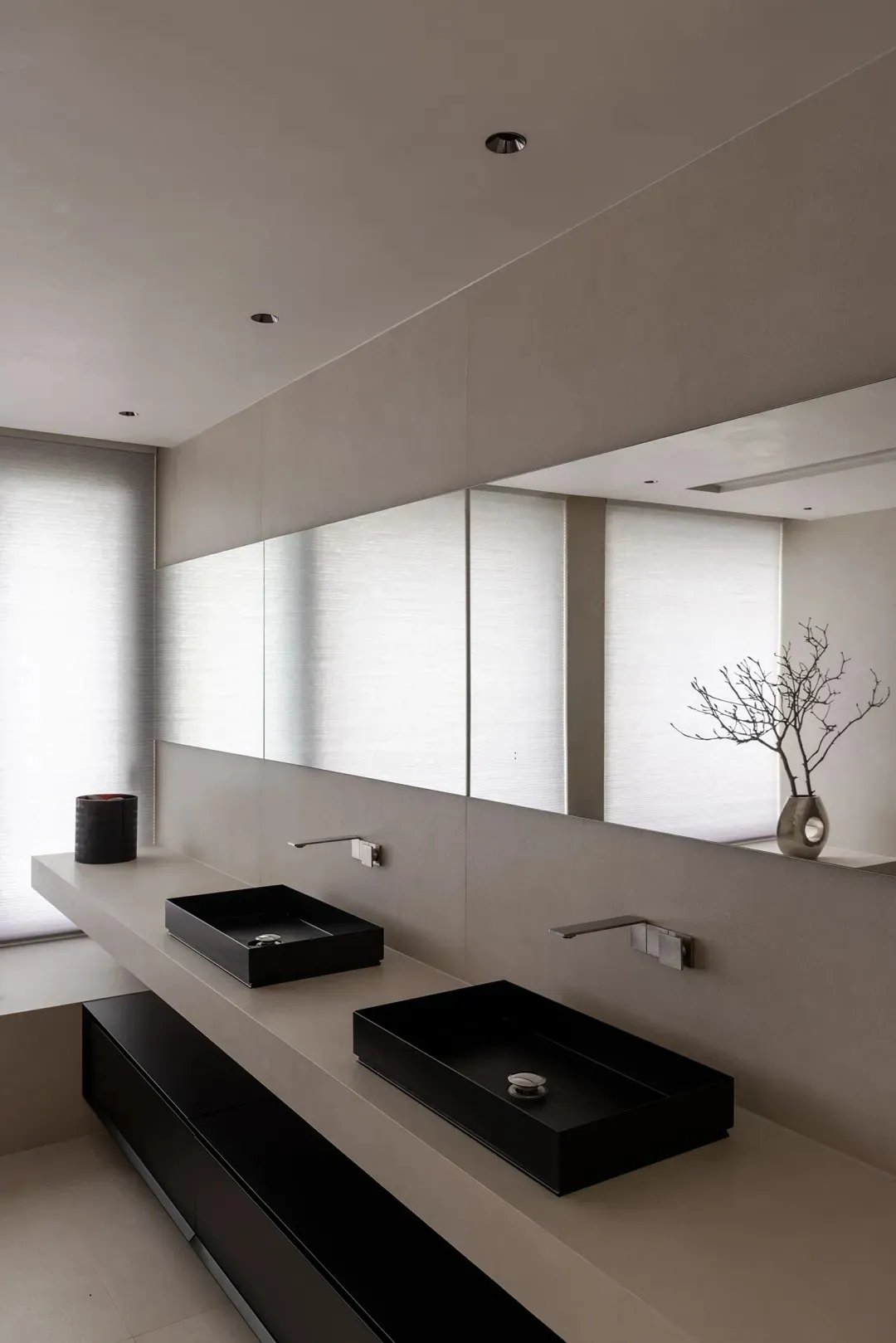 Modern minimalist bathroom with glass sinks and large mirror.