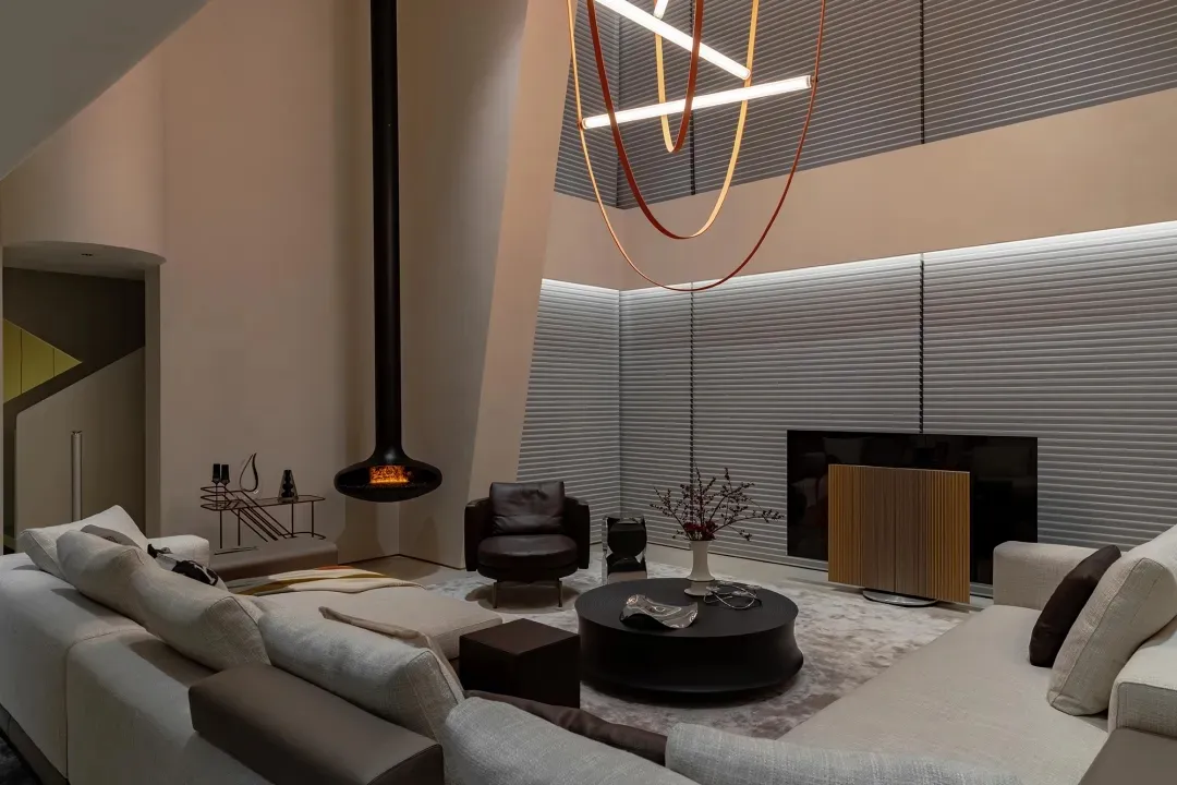 Modern living room with metallic decor, glass elements, wooden accents, and fabric furniture