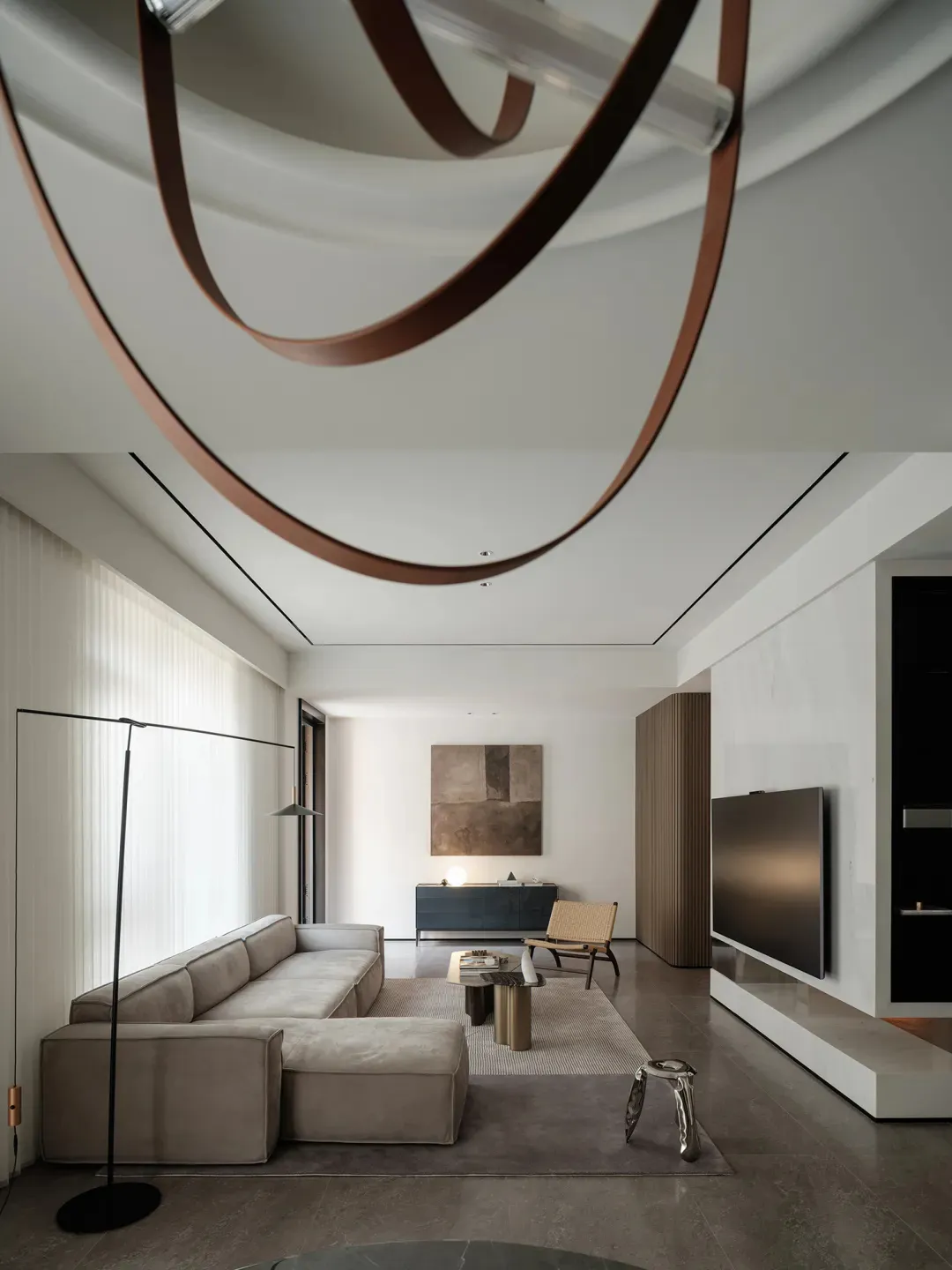 Modern minimalist living room with concrete, leather, and wood finishes