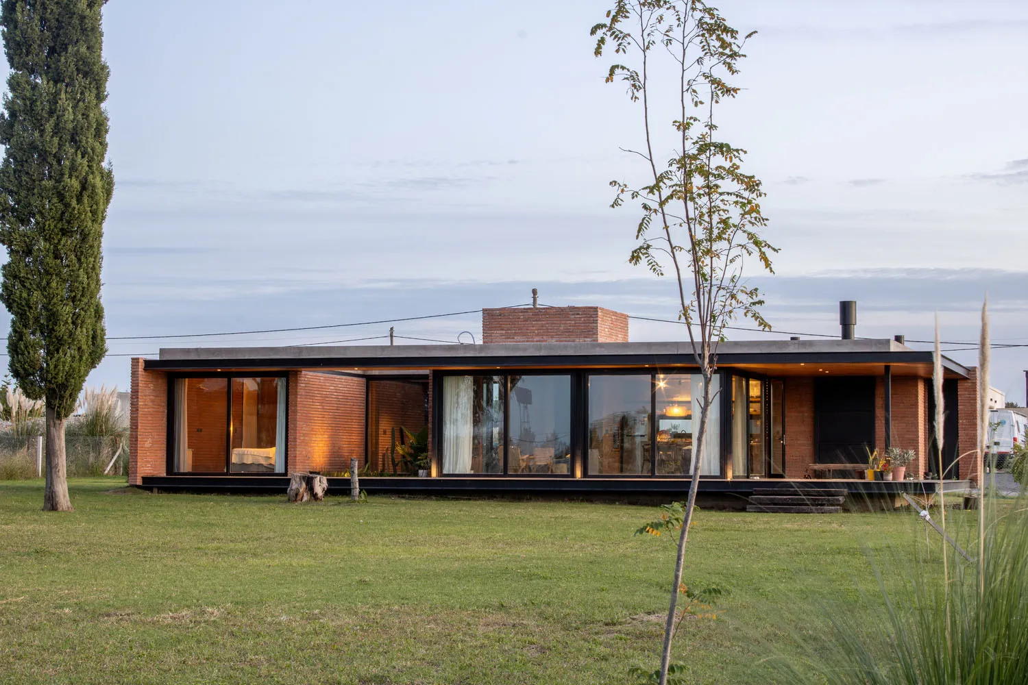 A modern house with brick and large glass windows.