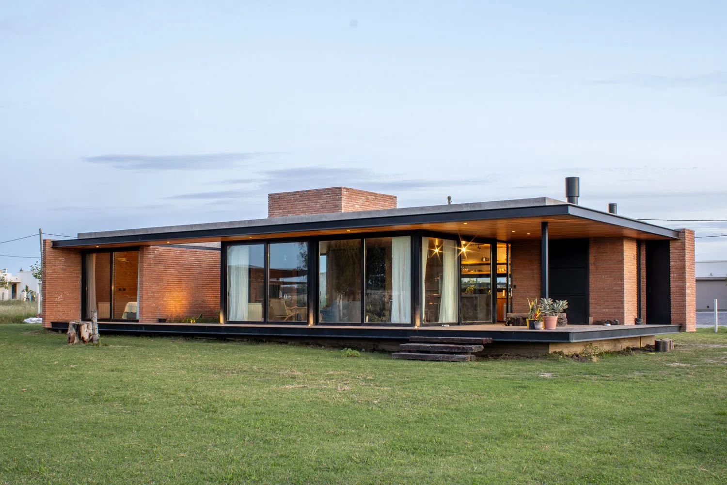 A modern residential exterior featuring brick and glass materials.