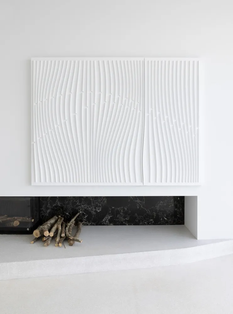 Modern minimalist interior design featuring textured concrete floor and marble fireplace with firewood.