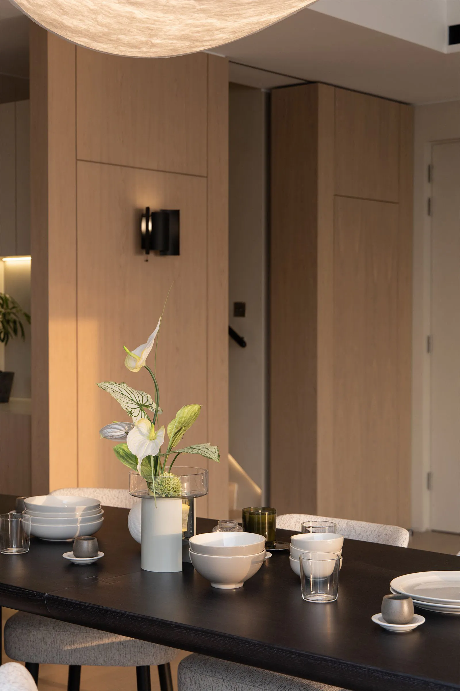 A well-lit, modern dining room with wooden walls and ceramic tableware.