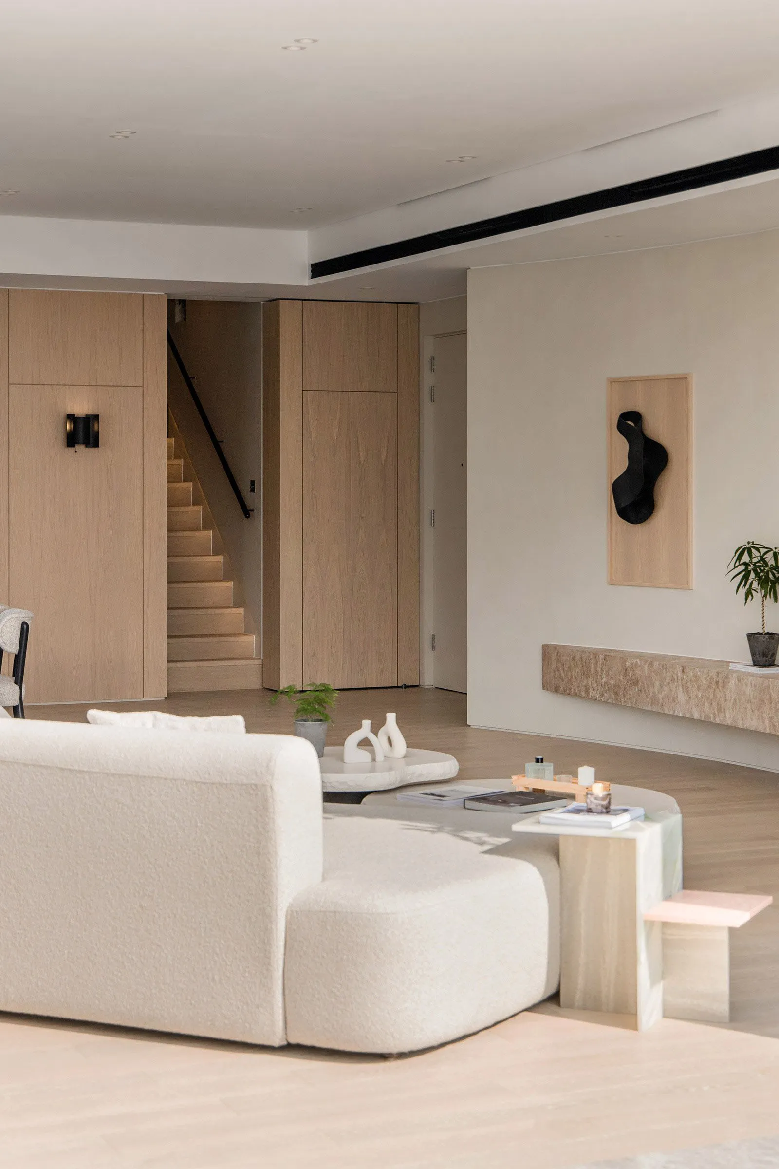 A modern living room featuring a white upholstered sofa, a round concrete side table, and a minimalistic decor scheme.
