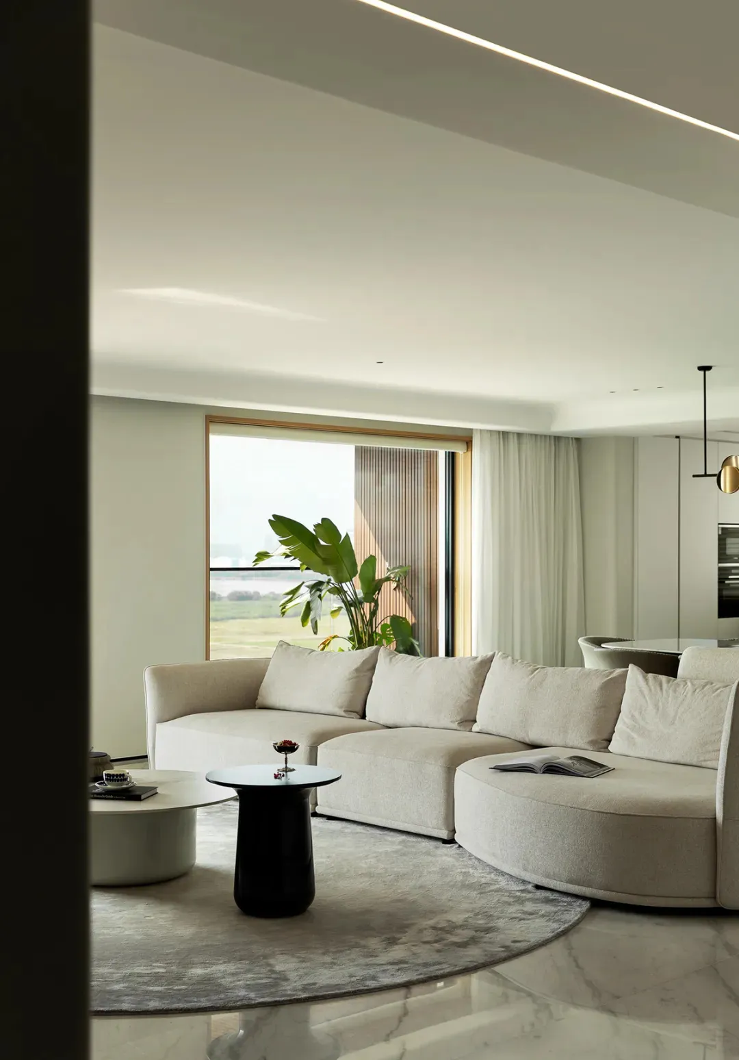 Modern residential living room featuring a comfortable fabric sofa on a stylish marble floor, accented by a sleek glass table