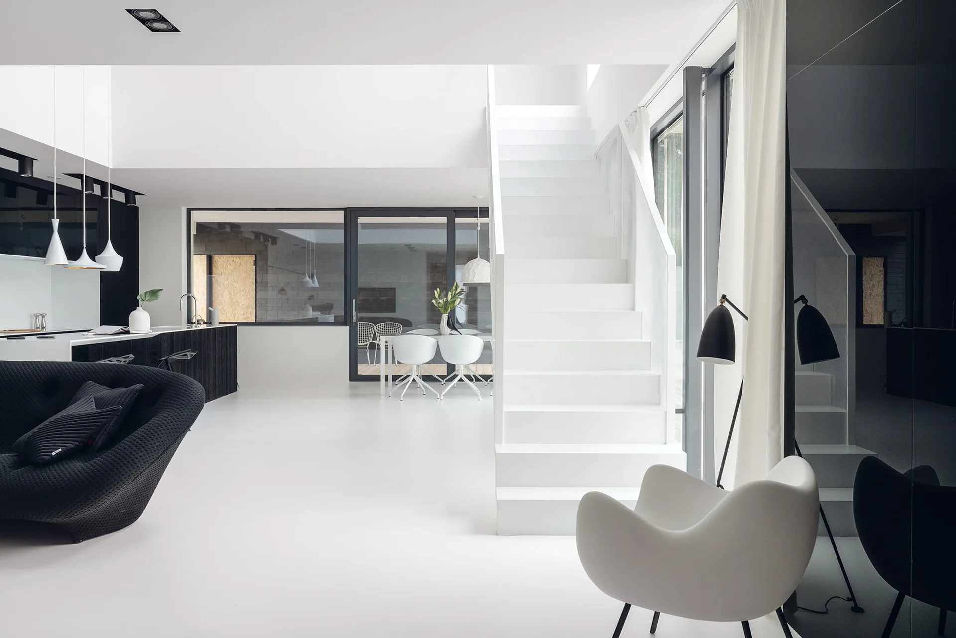 A modern residential interior with white walls, minimalist furniture, and black accents.