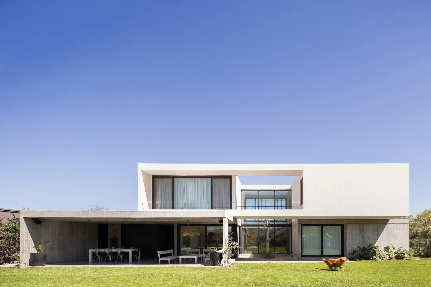 A modern residential exterior with a minimalistic, concrete and glass design.