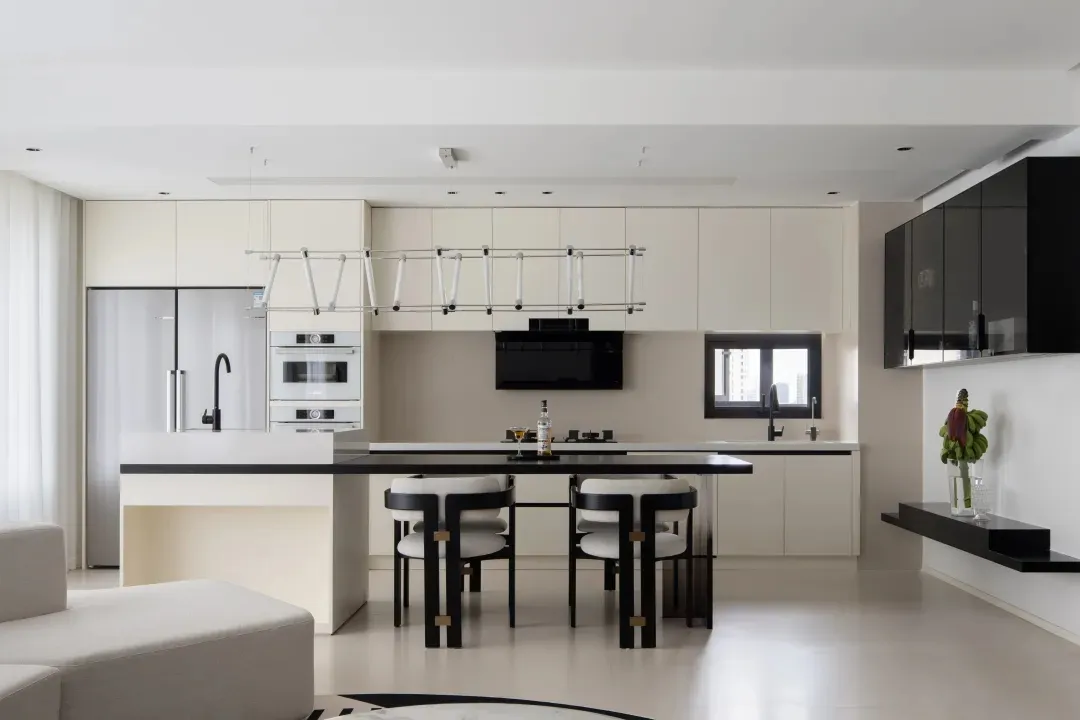 Minimalist kitchen with black countertops and white cabinetry and chairs