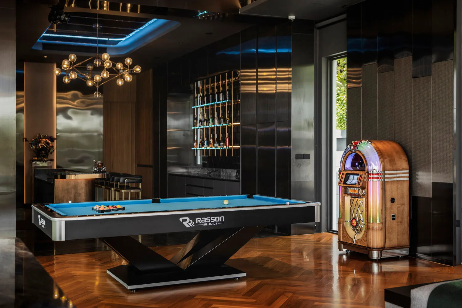 A modern minimalist living room featuring a wooden floor and glass walls, with a pool table and jukebox.