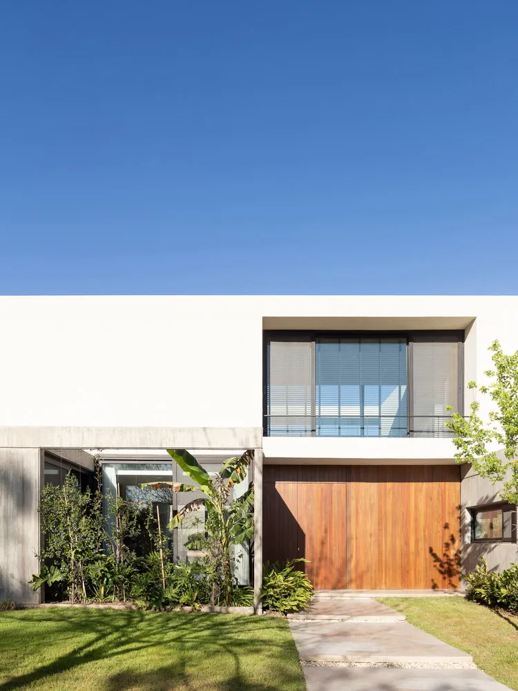 A modern residential exterior with concrete walls and wooden accents.
