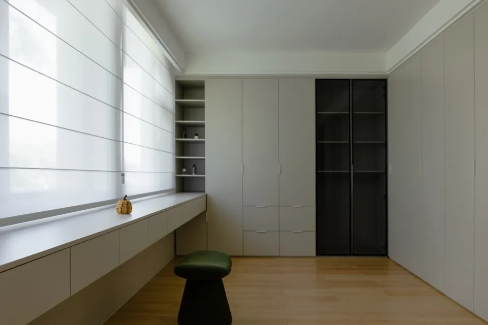 Modern closet with concrete walls and floor tiles, featuring organized storage cabinets and shelves.