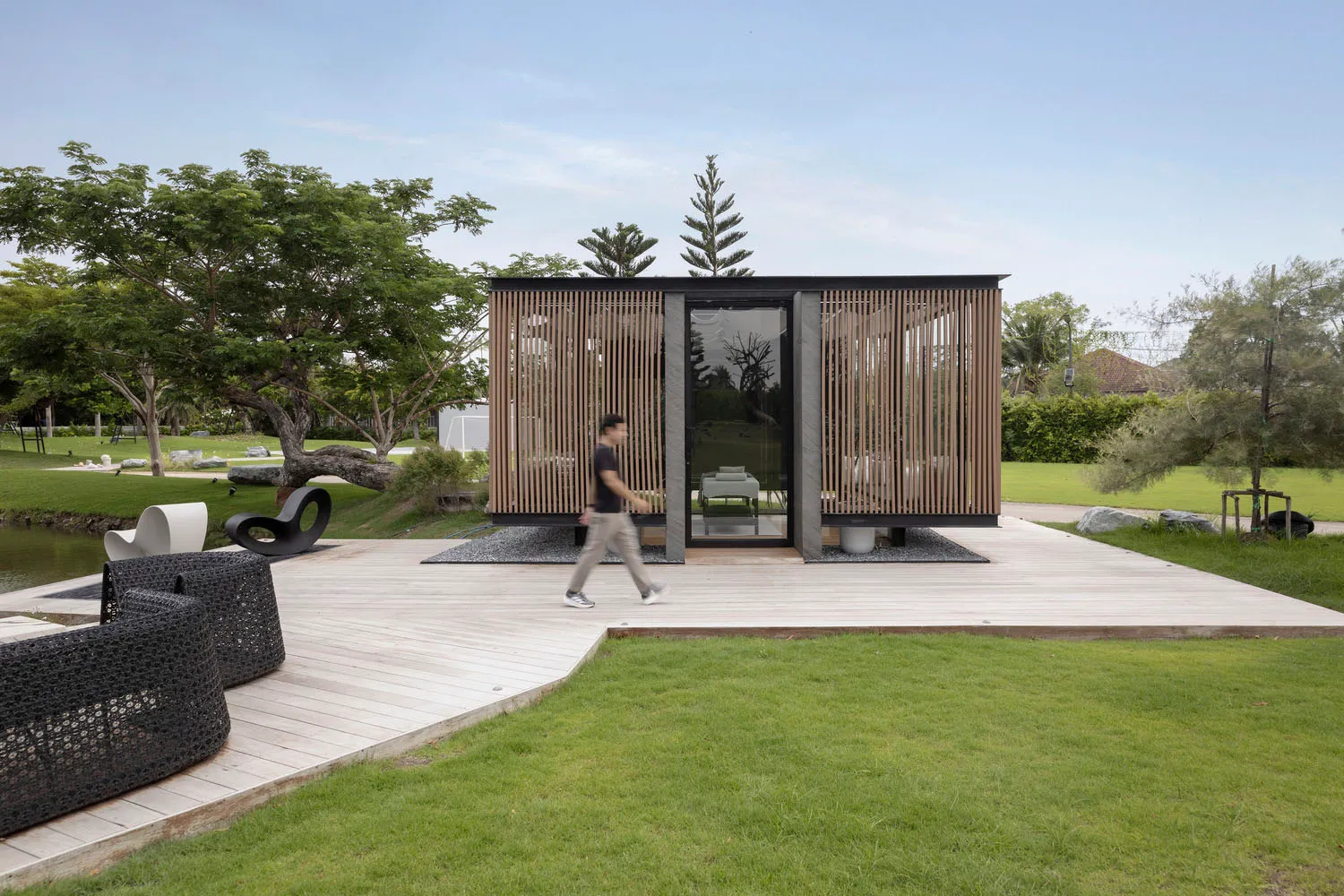A modern minimalist pavilion with wood, glass, and stone materials