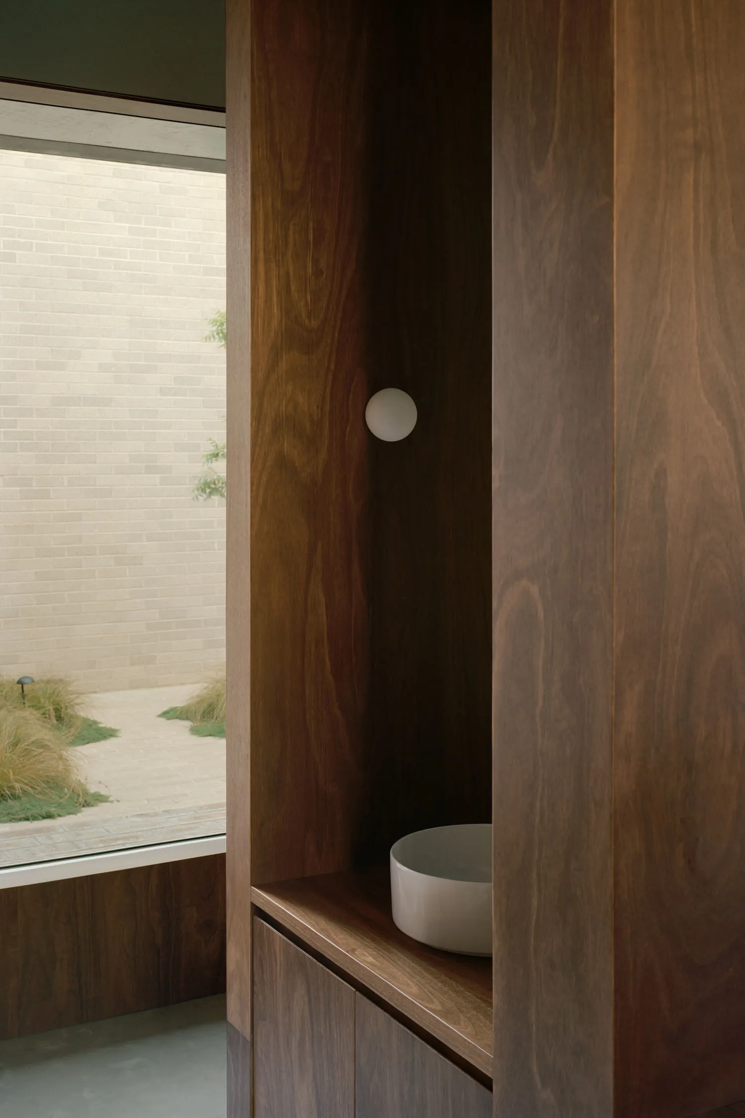 Modern bathroom with wooden cabinets and a white sink.
