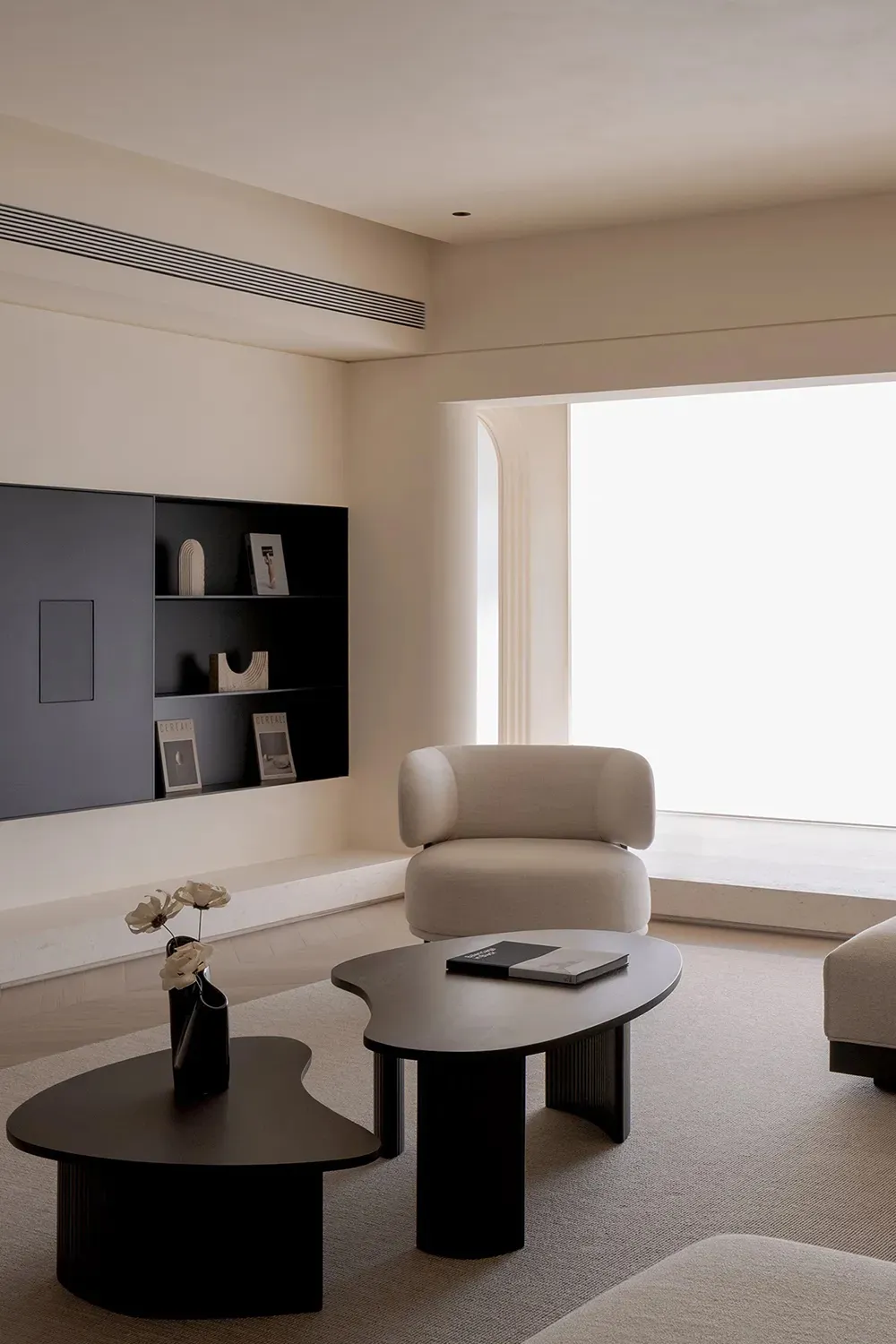 Contemporary minimalist living room featuring fabric lounge furniture and unique black metal tables.