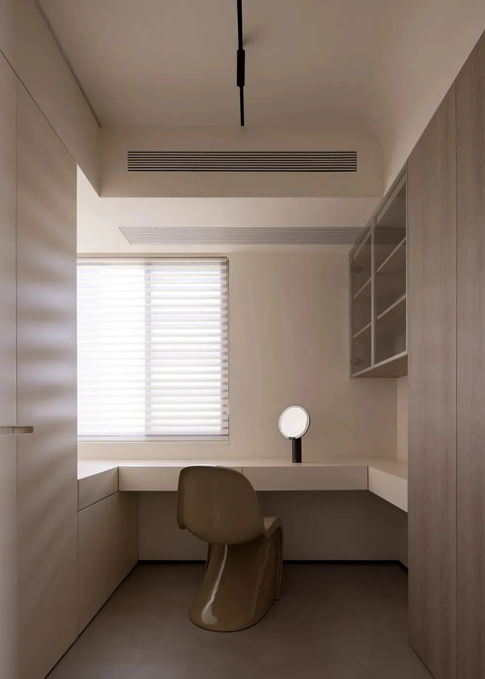 Minimalist workspace featuring a wooden desk and modern chair, suitable for a home office or study area.