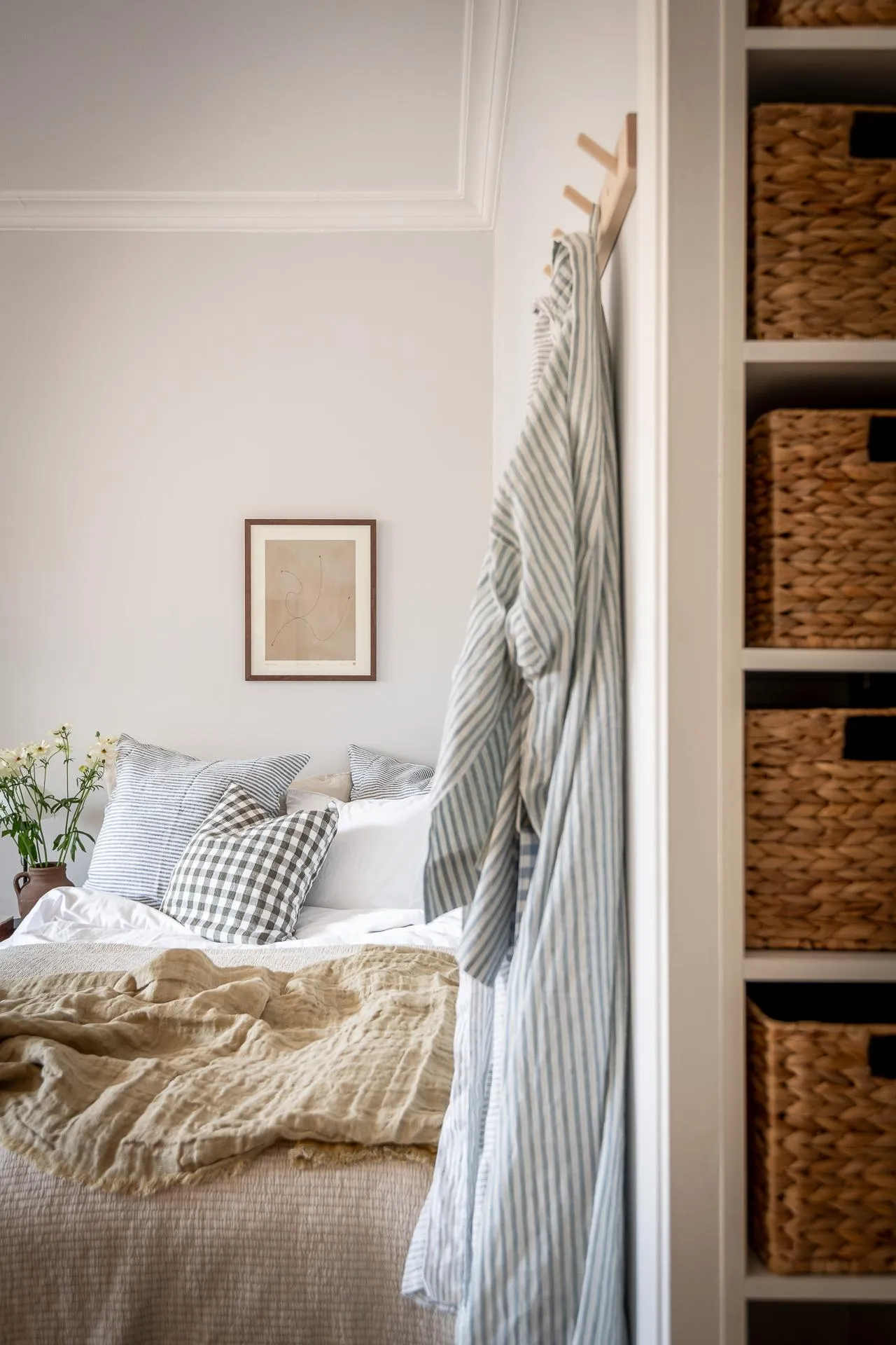 A minimalist bedroom with textiles, woven baskets, and wooden elements.