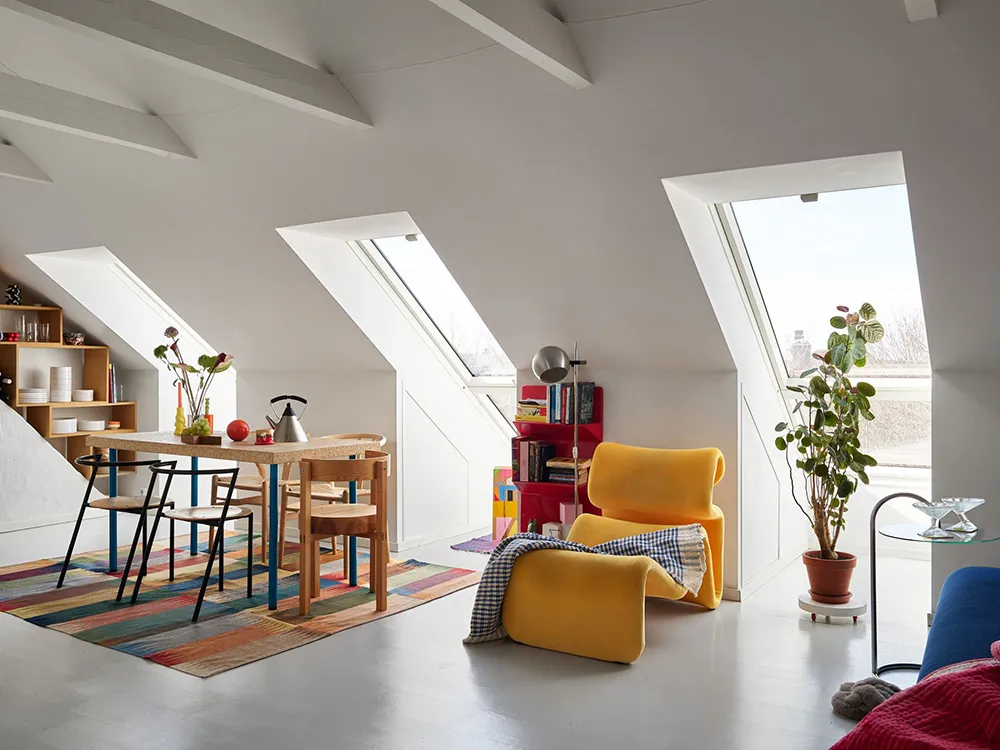 A minimalist living room with wood furniture, large windows, and modern decor.