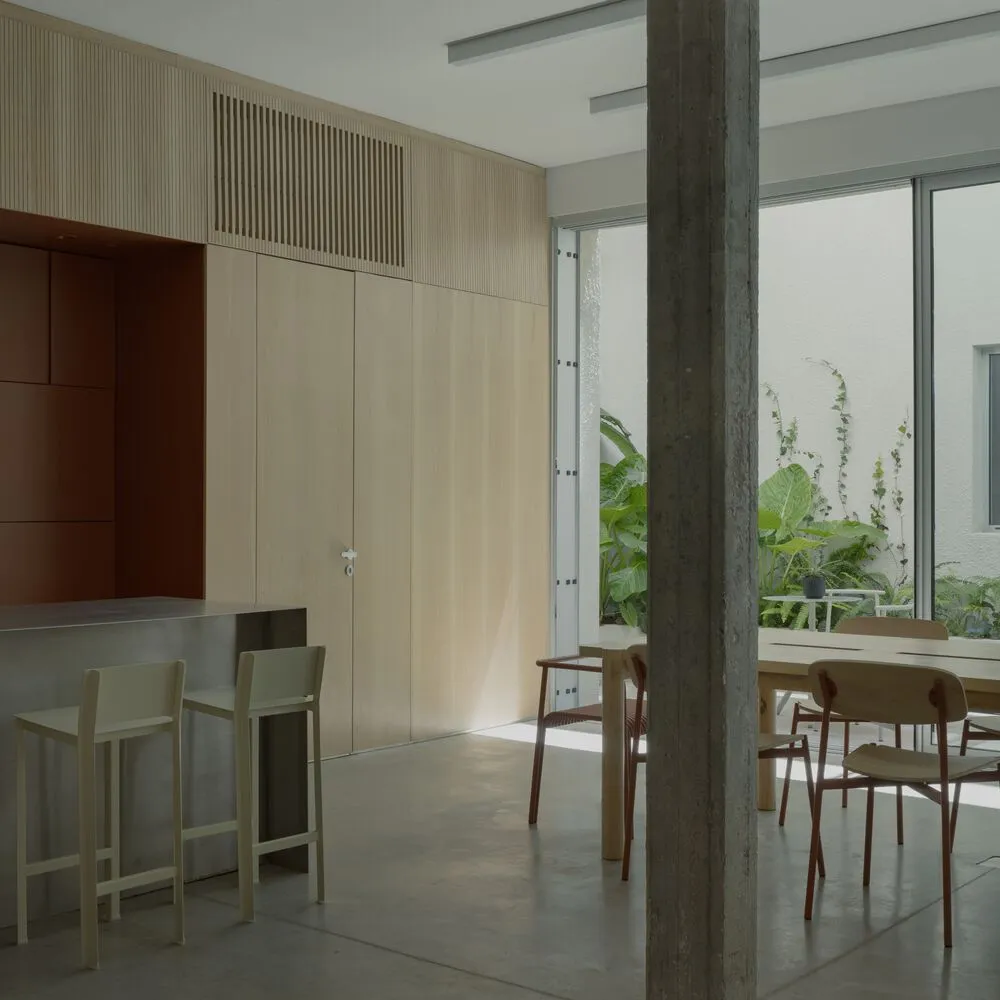Minimalist dining room featuring modern furniture, concrete floor, and natural wood accents.