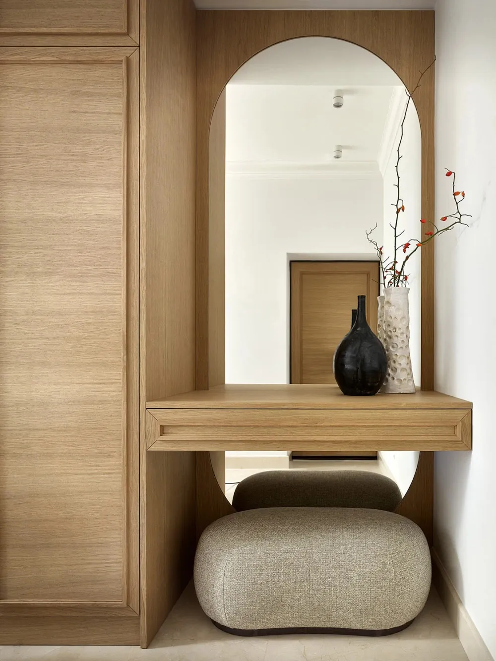 A modern minimalist interior with a wooden desk and stool.