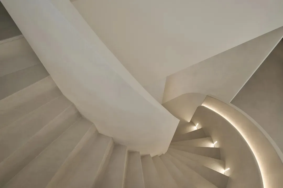 Modern concrete staircase with illuminated railings.