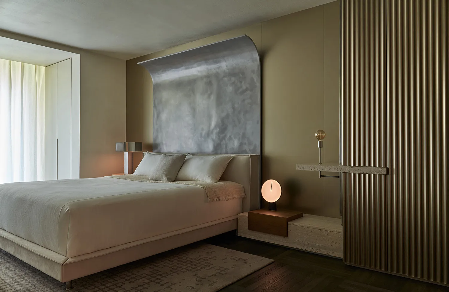 A modern bedroom with a metallic wall feature and a cozy bed setup.