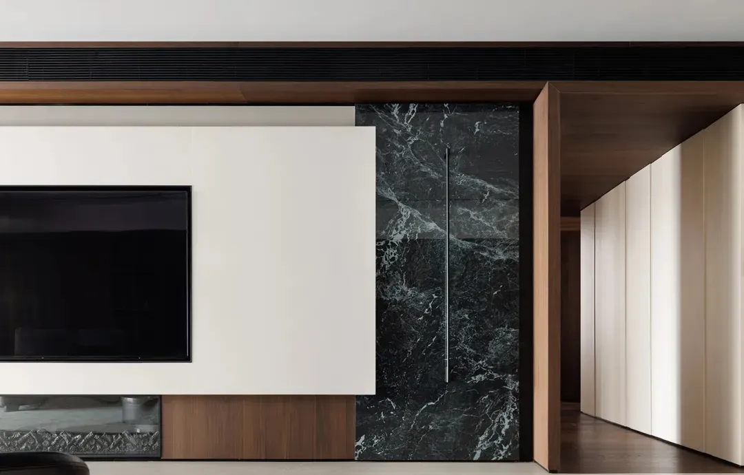 Modern minimalist living room featuring marble walls and wooden elements.