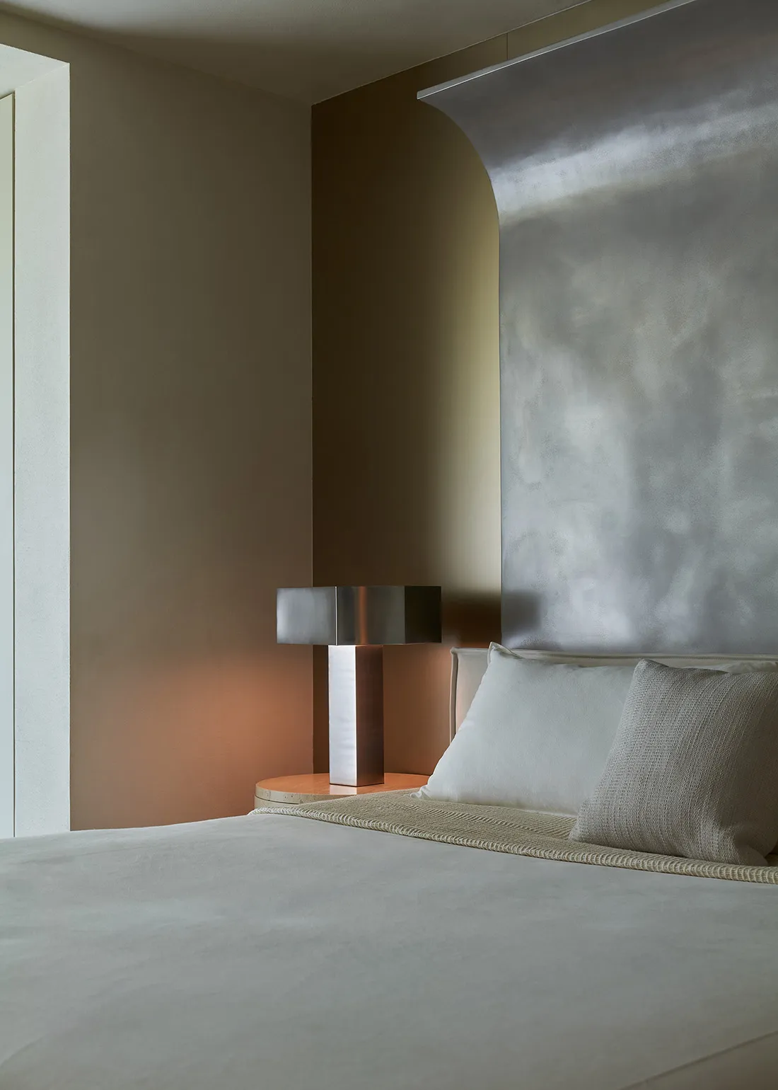 Modern bedroom featuring a textured wall and minimalist furniture