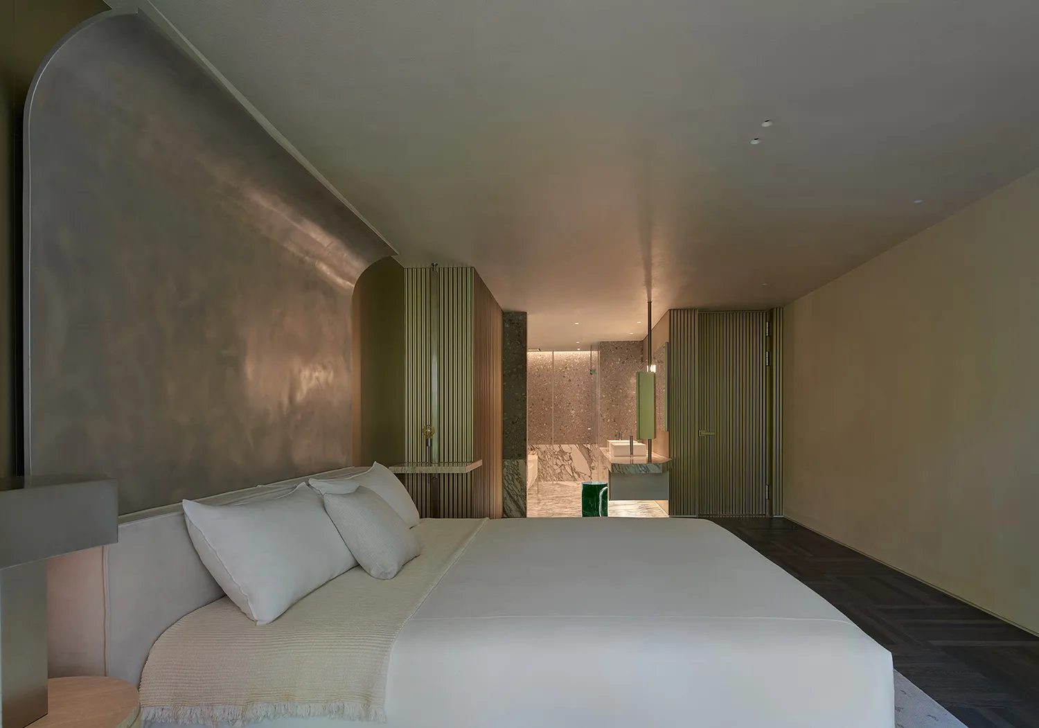 A modern bedroom with neutral-toned materials and a minimalist design.