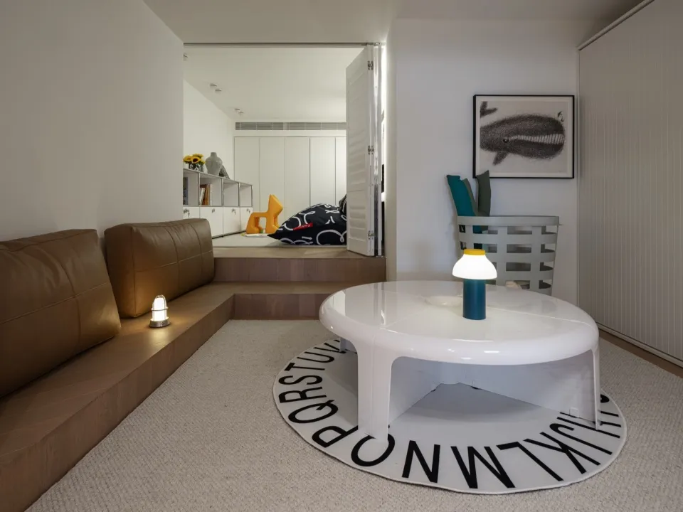 A modern living room with a round table and a sofa.