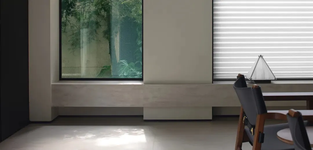 Modern minimalist office space with a window view of an indoor garden.