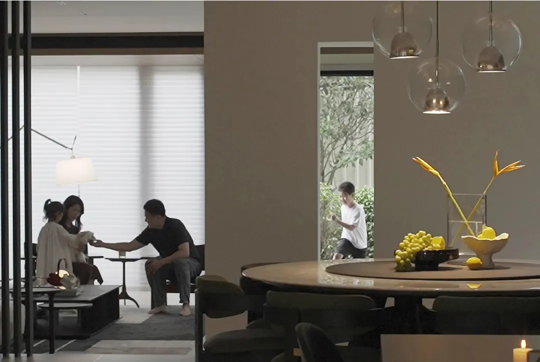 A modern residential dining room featuring a round dining table with a fruit bowl and a family of four interacting in the adj