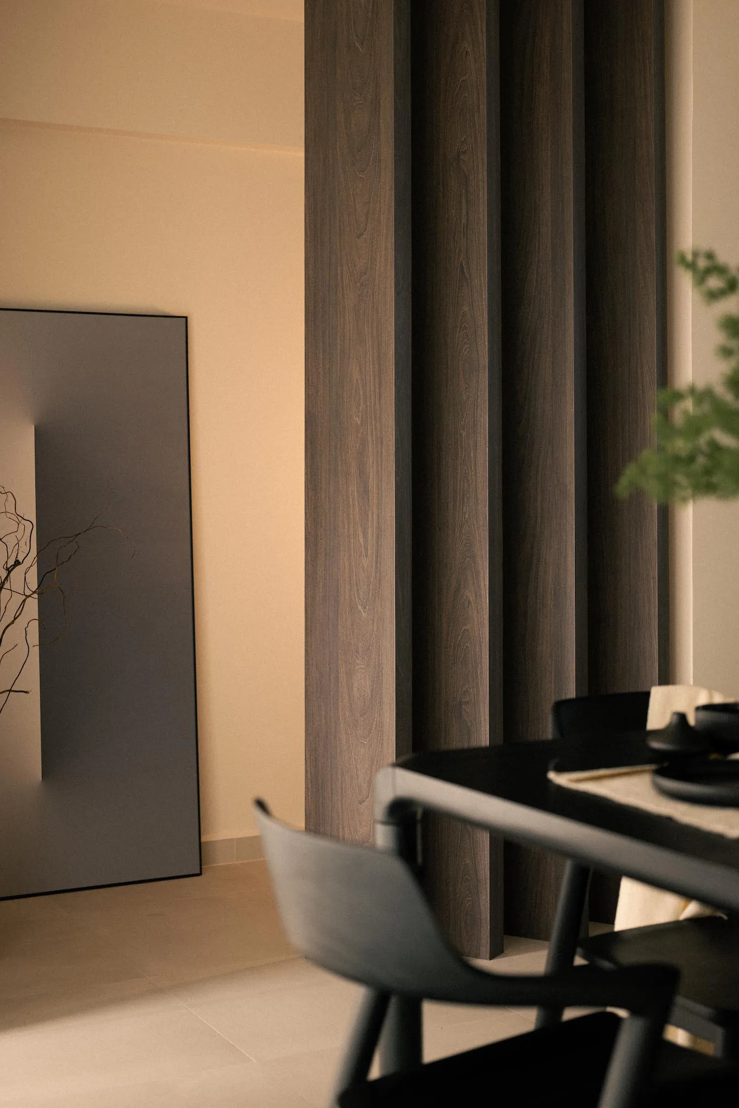 Modern minimalist dining room with black wooden panels and chairs.