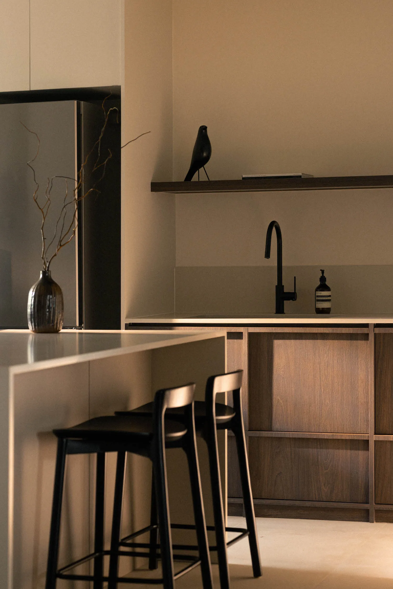 A minimalist kitchen with wooden cabinetry and a sleek, modern design.