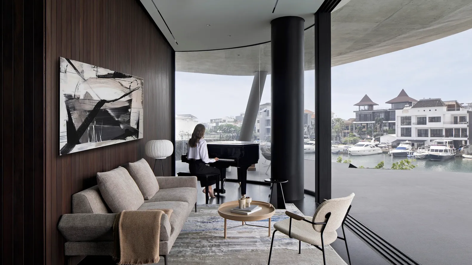 A modern living room featuring a wooden sofa, glass coffee table, and concrete floor with a grand piano and cityscape view.