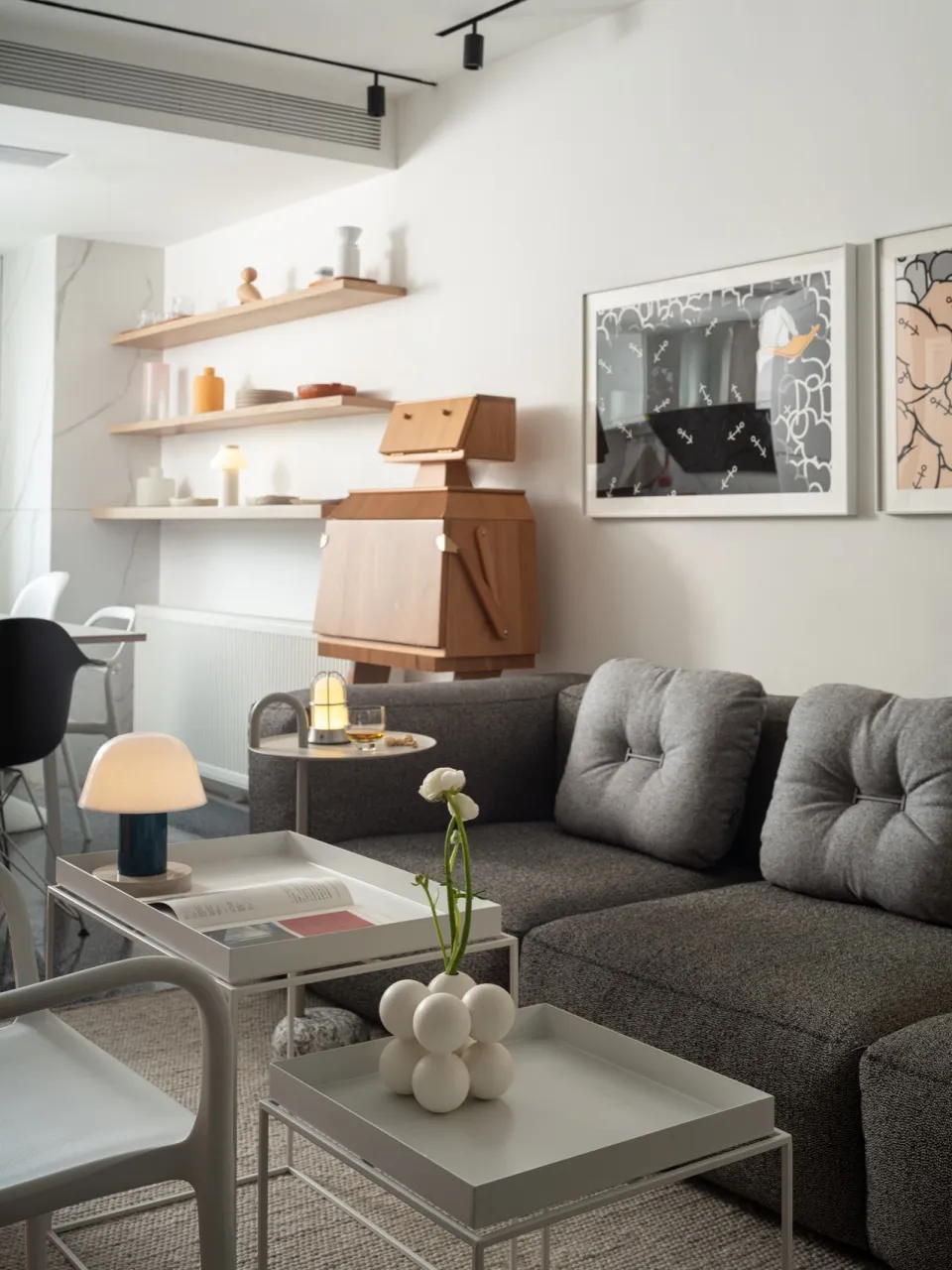 A modern living room with a textured gray sofa, metal coffee table, and wooden coffee table.