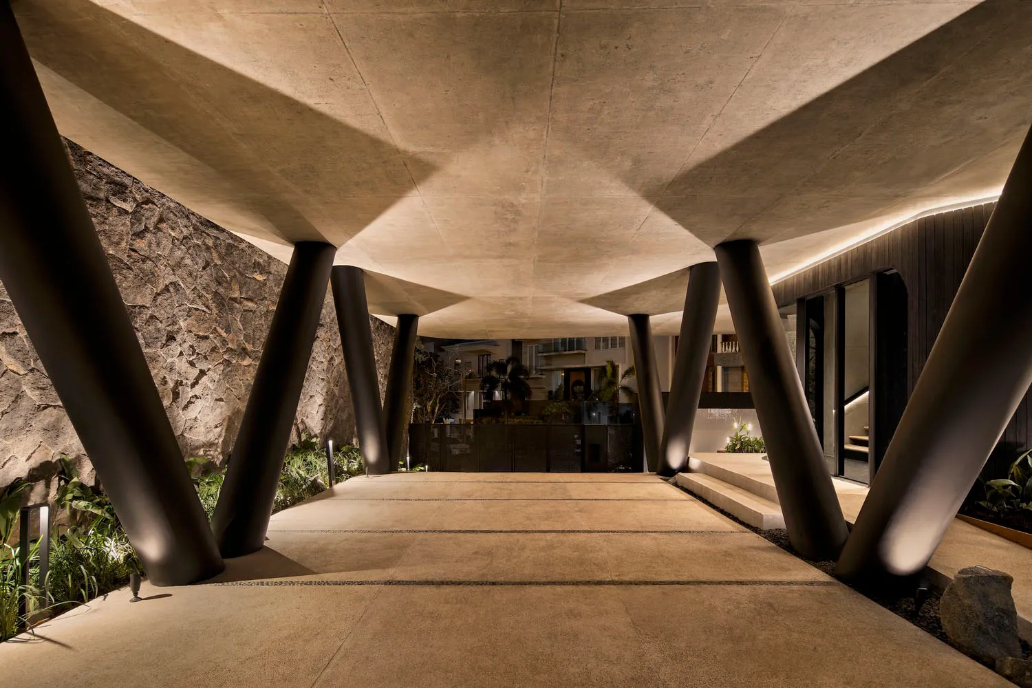 A modern entrance featuring a concrete structure with large pillars.