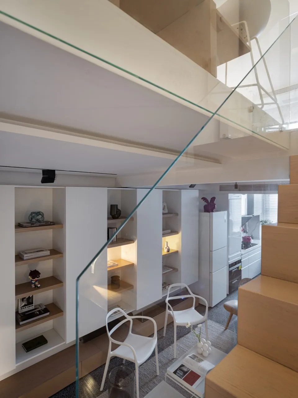 Modern minimalist living room featuring a glass staircase, wooden floor, and white decor.