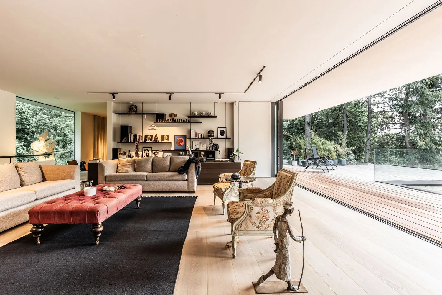 A modern living room with wooden furniture, large windows, and a comfortable seating area.