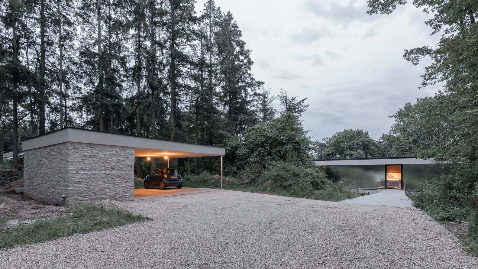 A modern residential exterior with stone, glass, and metal elements.