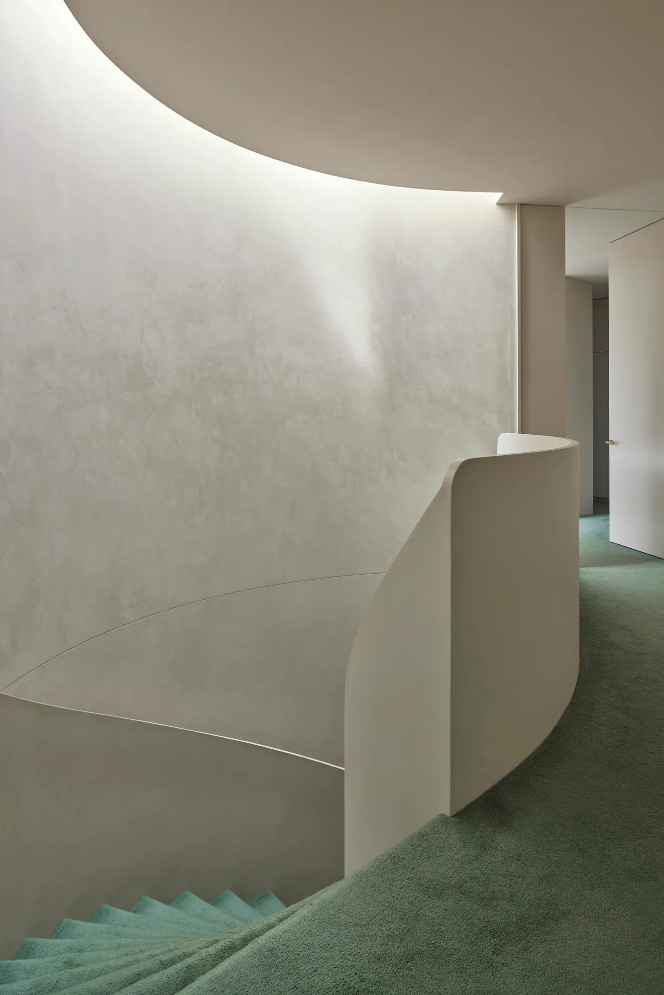 Modern, minimalist staircase constructed from concrete materials, featuring a sleek, curved design.