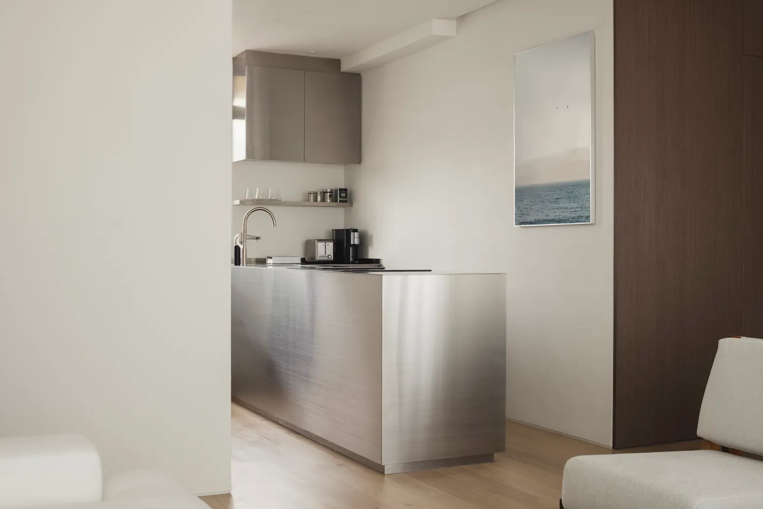 Modern, minimalist kitchen design featuring a sleek metal countertop.