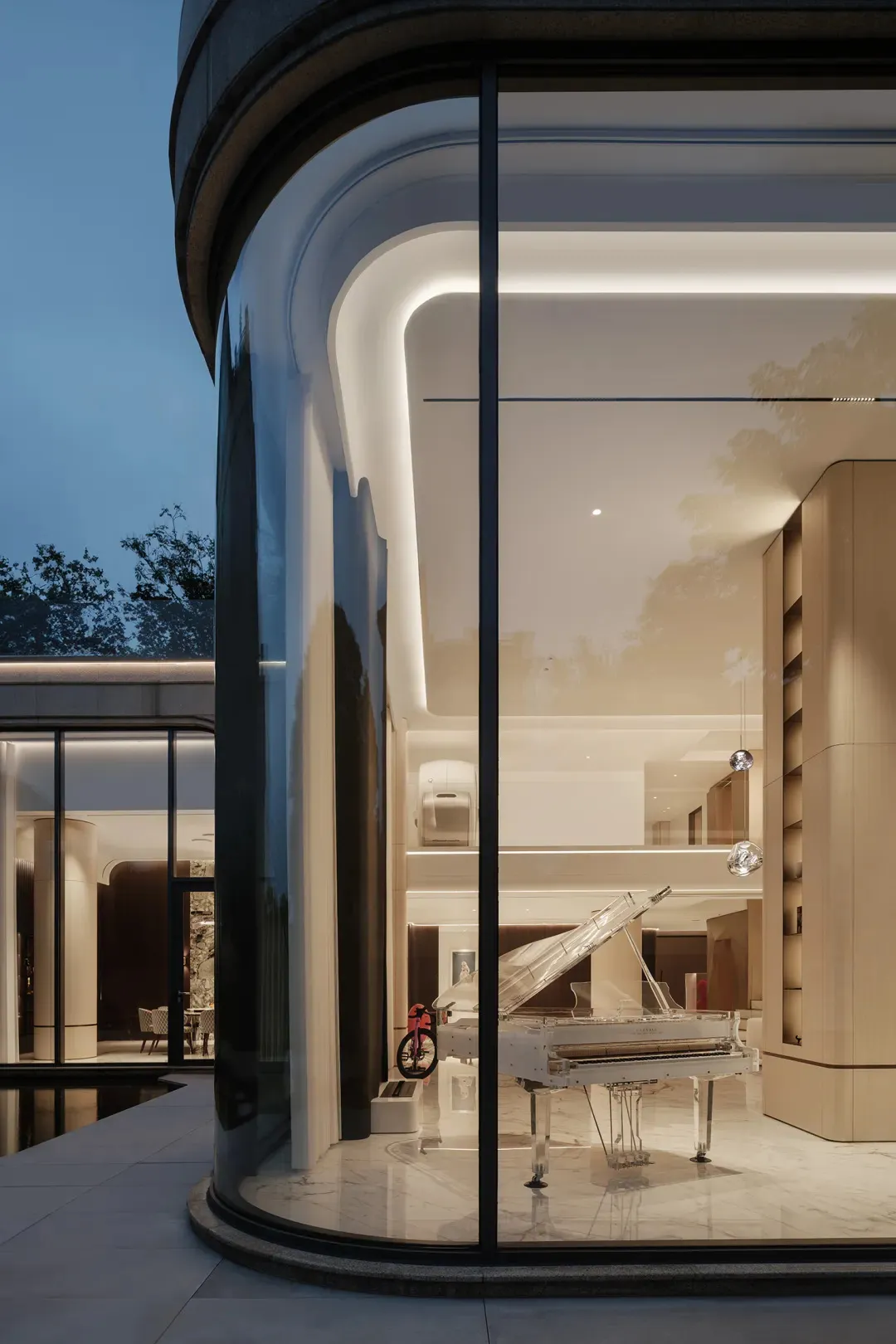 Modern living room featuring glass walls, marble flooring, and wooden accents.