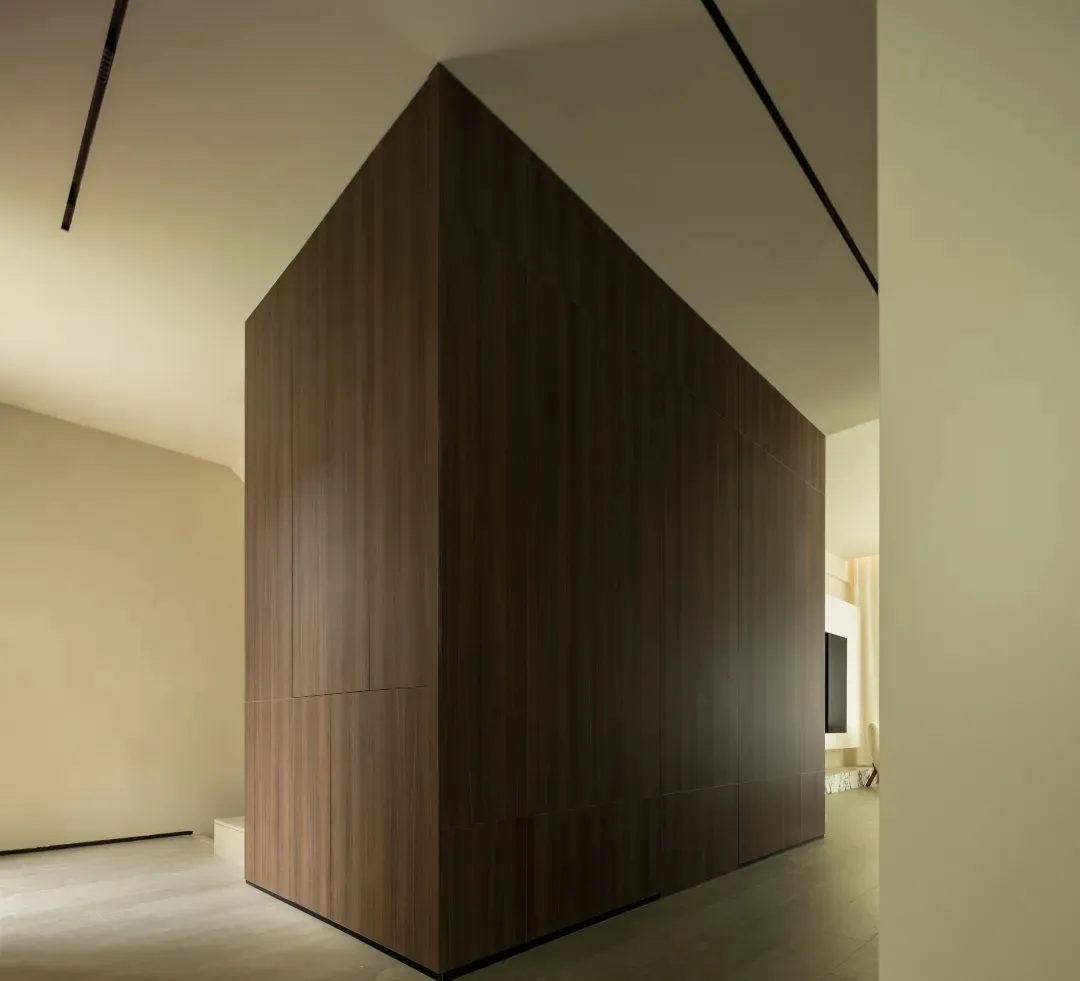 A modern living space featuring wood-paneled walls, minimalist furniture, and a sleek, contemporary aesthetic.