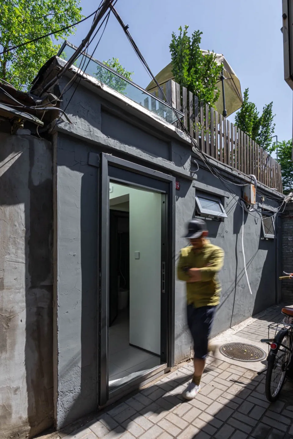 A modern, minimalist residential exterior with concrete walls and a glass door.